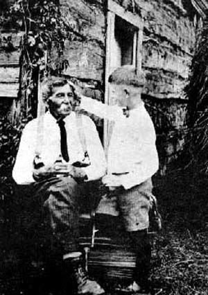 Antoine Vandal with Paul Rajotte in front of first log church, St. Jean Baptiste, 12 August 1928