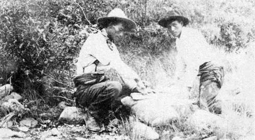 Making bannock and cutting pork on the Burntwood River, 1910.
