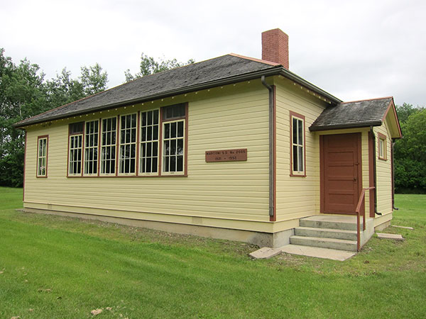 The restored Marconi School in the RM of Rossburn has an attached teacherage and separate outhouses for girls and boys.