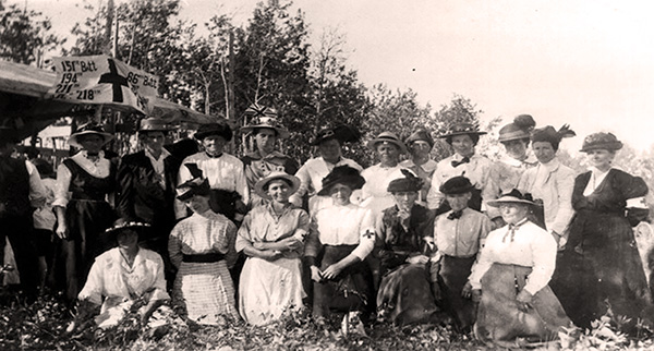 Women quilters at the Red Cross Auxiliary picnic on the Bishop Farm at Waskatenau, Alberta, in the summer of 1917.