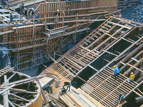 Workers build wooden forms for two draft tubes at the future Kelsey Generating Station.