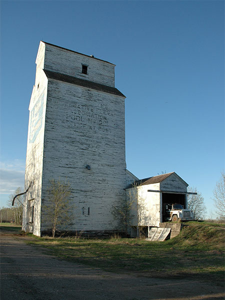 The former United Grain Growers grain elevator at Bellsite with its Manitoba Pool markings visible under the peeling paint
