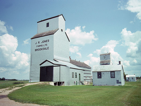 Former Manitoba Pool grain elevator at Brookdale, with the original office at right, and the United Grain Growers elevator in the background
