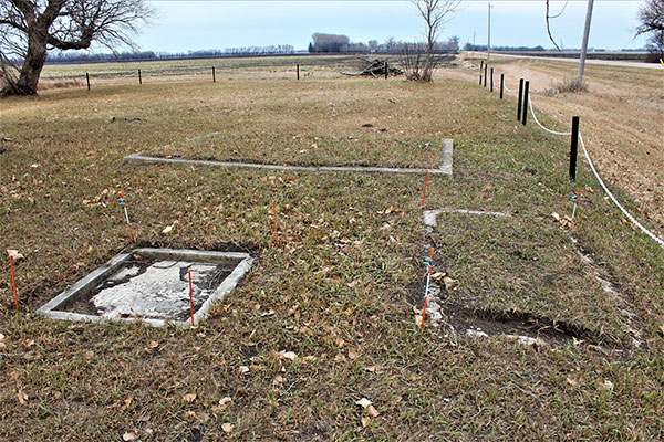 Two unmarked graves in foreground with Mary Driedger's grave behind them