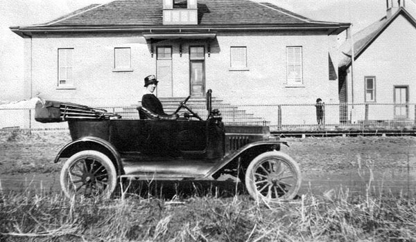 Principal Inez A. Hill in her car beside the new (left) and old (right) Fairfax schools