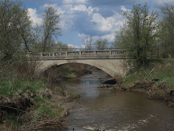 Abandoned concrete arch bridge over the South Garland Creek