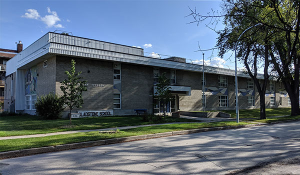 The present-day Gladstone School with the namestone of its predecessor school on the left front side