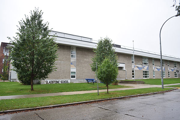 The present-day Gladstone School with the namestone of its predecessor school on the left front side