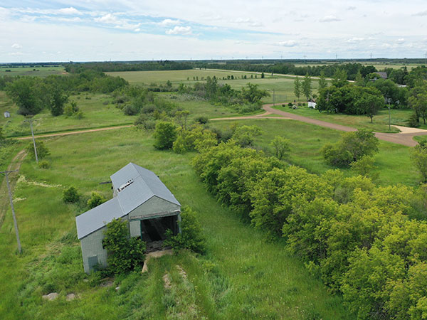 Aerial view of the former elevator driveshed and office and overgrown railway line