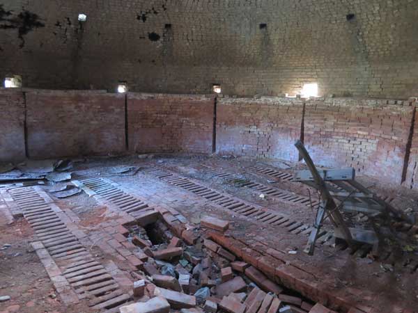 Interior of the beehive kiln showing the grated floor and brick wheelbarrow at right