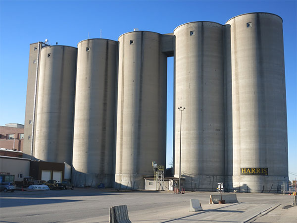 Five concrete silos formerly used for storing processed white sugar, the three at left being constructed in early 1962