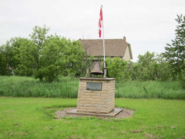Millwood School commemorative monument with school building in background