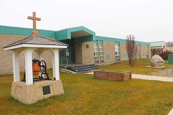 Bell from an earlier Notre Dame de Lourdes School building in front of the present-day elementary school