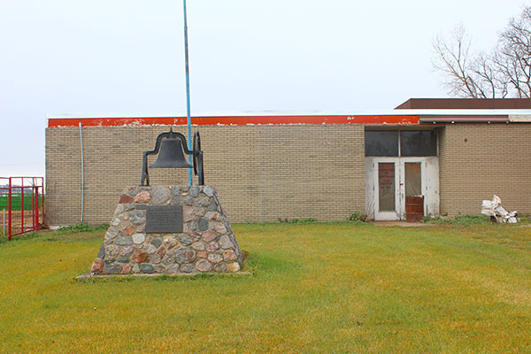 Rathwell School commemorative monument with the former school building in the background
