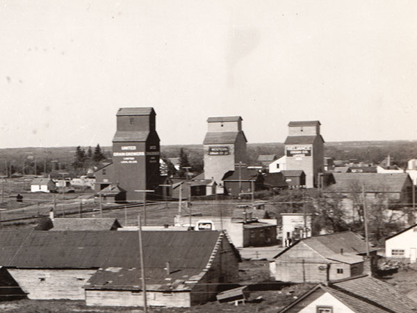 Pioneer grain elevator at Strathclair, owned at the time by the Western Grain Company, and bracketed on each side by a United Grain Growers grain elevator on the left and a Reliance Grain Company grain elevator on the right