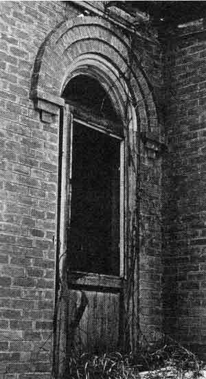 Romanesque arch frames the fanlite that once held ruby glass from France.