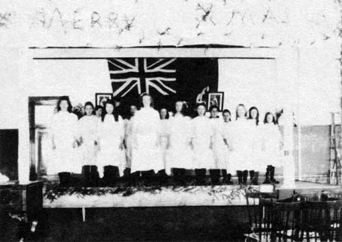 Interior of school classroom decorated for Christmas concert, circa 1915.