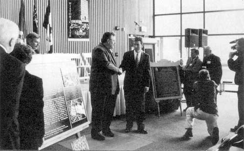 At a ceremony held at Pantages Playhouse Theatre on 2 October, plaques for the Exchange District and Union Bank national historic sites were unveiled. Federal MP Reg Alcock shakes hands with Winnipeg Mayor Glen Murray.