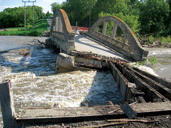 An impressive triple-arch concrete bridge over the Assiniboine River, in the village of Millwood in the Rural Municipality of Russell, was built in 1920, replacing an earlier wooden structure. Aside from minor damage to the balusters of its railings, it is in good condition.