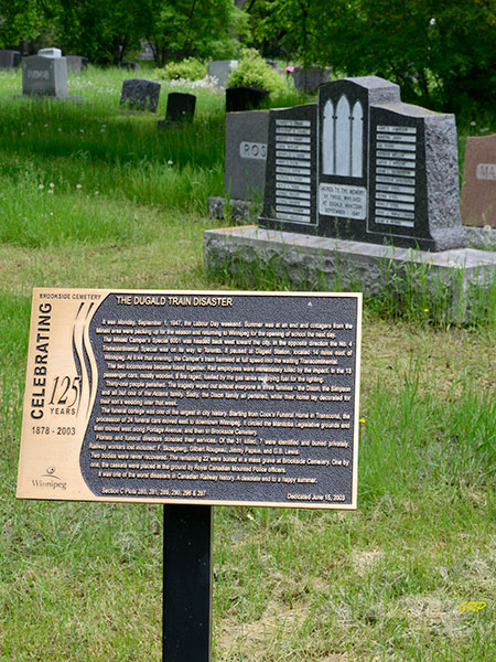 "Teardrop" plot in Commemorative plaque and monument in Brookside Cemetery for victims of the Dugald Train Disaster