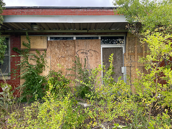 Overgrown entrance to the administrative offices of the former Campbell Soup plant at Portage la Prairie
