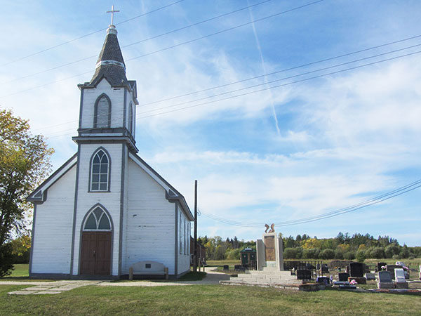 Hecla Island Lutheran Church with an associated monument and cemetery
